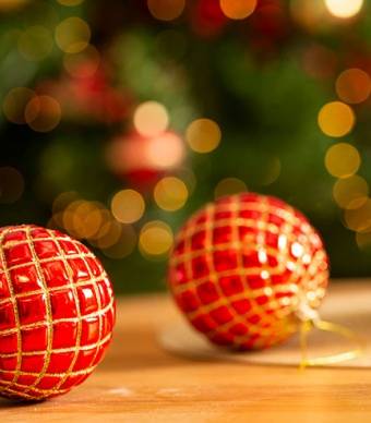 Bolas de Natal vermelhas e douradas em cima de uma mesa